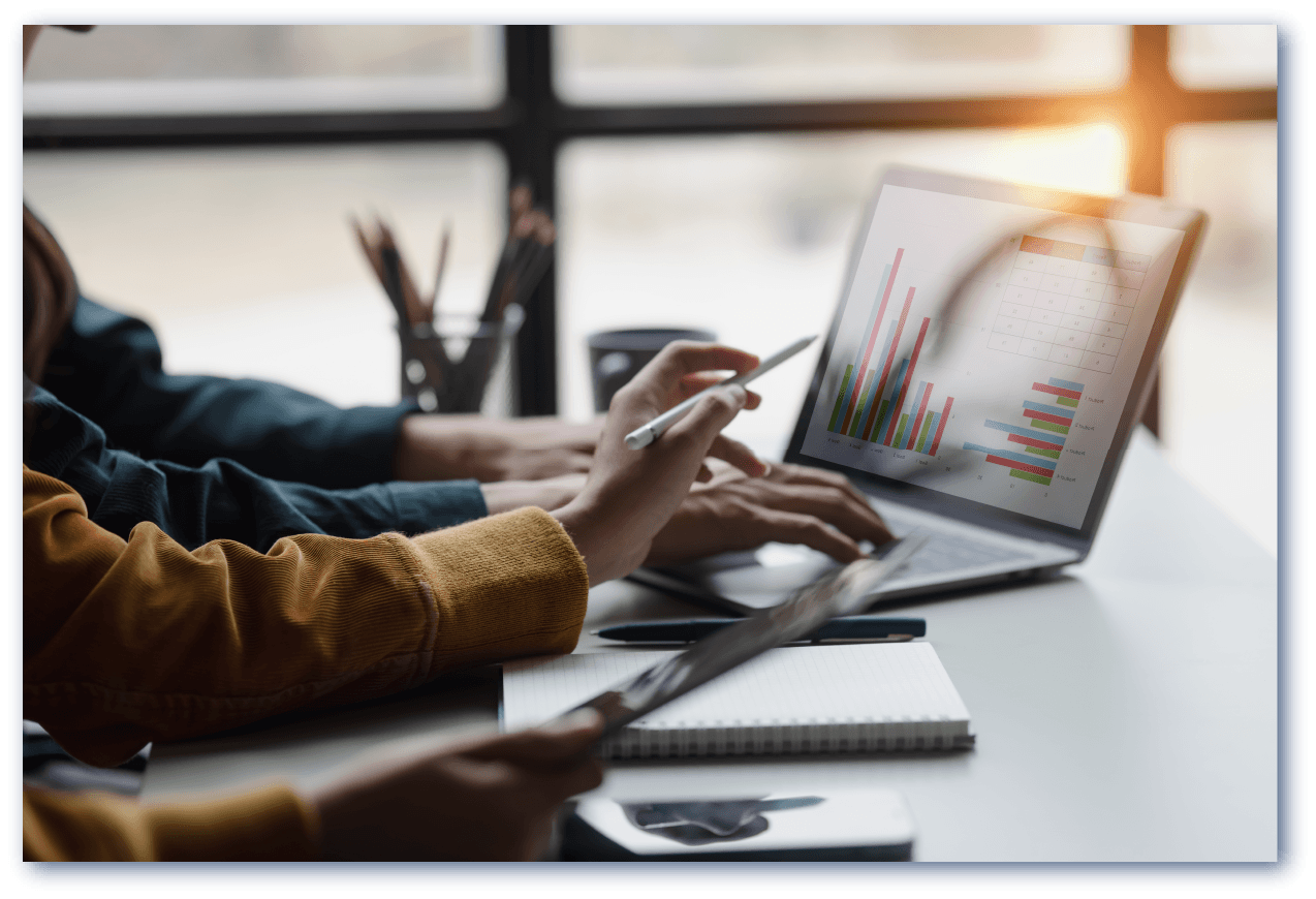 パソコンでデータを見ながら会議をしている写真